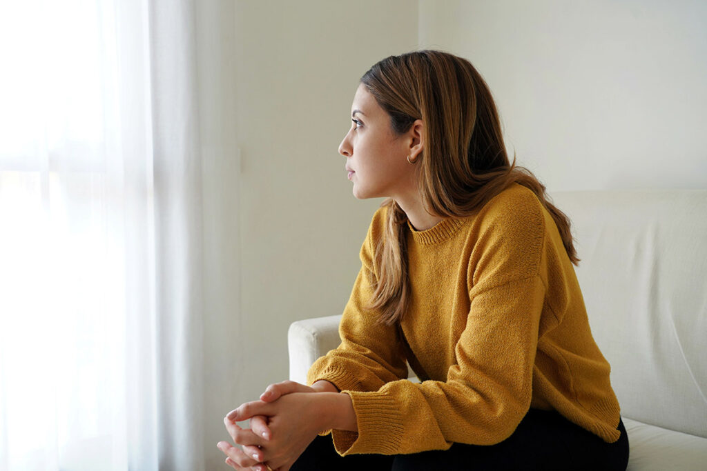 Person looking out window and thinking about their PTSD triggers